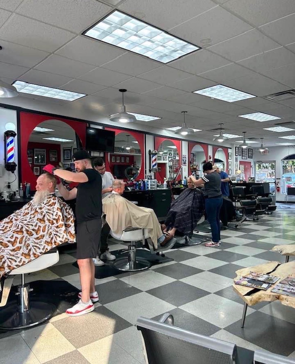Barbers at work in a full row of chairs at Alfred's